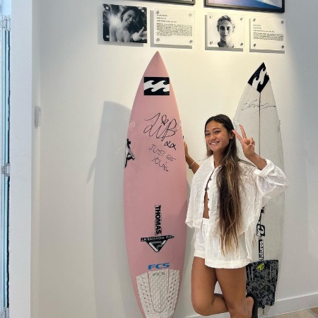 Lilliana Bowrey showing her signed surfboard.